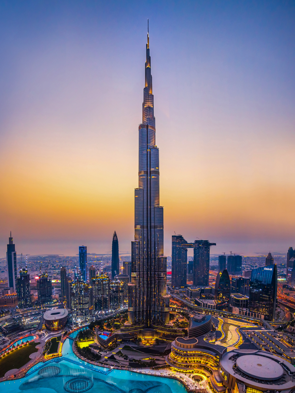 Dubai, United Arab Emirates - July 5, 2019: Burj khalifa rising above Dubai mall and fountain surrounded by modern downtown buildings top view